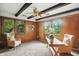 Bright bedroom with wood panel walls, a ceiling fan, and natural light from large windows at 7736 Wawasee Dr, Indianapolis, IN 46250