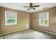 Bedroom featuring two windows, neutral walls, ceiling fan, carpet and baseboard heat at 7736 Wawasee Dr, Indianapolis, IN 46250