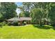 Charming brick home with a well-maintained lawn, mature trees, and a red front door at 7736 Wawasee Dr, Indianapolis, IN 46250