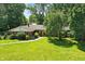 Beautiful single-story home with a vibrant green lawn and a red front door at 7736 Wawasee Dr, Indianapolis, IN 46250