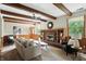 Spacious living room with beamed ceilings, a brick fireplace, and large windows at 7736 Wawasee Dr, Indianapolis, IN 46250