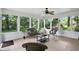 Relaxing sunroom with wicker furniture, a ceiling fan, and views of the lush backyard at 7736 Wawasee Dr, Indianapolis, IN 46250