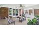 Charming sunroom featuring wicker furniture, a ceiling fan, and views of the surrounding greenery at 7736 Wawasee Dr, Indianapolis, IN 46250