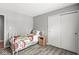 Simple bedroom featuring a twin bed, wood-look floors, and a sliding door closet at 792 Nevelle Ln, Carmel, IN 46032