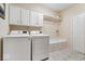 Functional laundry room equipped with modern appliances, white cabinets, and bench seating at 817 Hickory Way, Noblesville, IN 46062