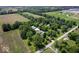 Aerial view highlights the home's setting amidst mature trees and agricultural fields at 881 W 1050 N, Fortville, IN 46040