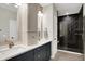 Bathroom features a double vanity, quartz countertops, gray cabinets, and a walk-in shower with subway tile at 906 Berkhamsted Ln, Carmel, IN 46032