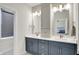 Bathroom with double vanity, white countertops, gray cabinets, modern lighting, and large mirrors at 906 Berkhamsted Ln, Carmel, IN 46032