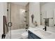 Bathroom featuring a shower with glass doors, neutral tile, and a blue vanity at 906 Berkhamsted Ln, Carmel, IN 46032