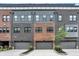 Modern townhouse exterior featuring brick and gray siding with attached garages at 906 Berkhamsted Ln, Carmel, IN 46032