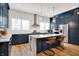 Stunning kitchen with navy cabinets, quartz countertops, large island and stainless steel appliances at 906 Berkhamsted Ln, Carmel, IN 46032