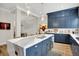 Open concept kitchen featuring stainless steel appliances, dark blue cabinets, and an island with a sink at 906 Berkhamsted Ln, Carmel, IN 46032