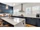 Well-lit kitchen featuring stainless steel appliances, dark blue cabinets, an island with breakfast bar at 906 Berkhamsted Ln, Carmel, IN 46032