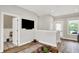 Bright living area with hardwood floors, recessed lights, powder room, TV and outdoor access at 906 Berkhamsted Ln, Carmel, IN 46032