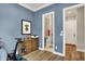Office area with hardwood floors, a desk, a peloton, and a door leading to a bathroom at 906 Berkhamsted Ln, Carmel, IN 46032