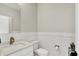 Elegant powder room featuring a modern vanity, sleek fixtures, and decorative wainscoting at 906 Berkhamsted Ln, Carmel, IN 46032