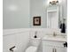 Quaint powder room with white wainscoting, pale blue walls, and a white vanity with marble countertop at 906 Berkhamsted Ln, Carmel, IN 46032
