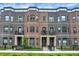 Beautiful townhomes featuring brick and wrought iron accents, plus manicured front yard at 906 Berkhamsted Ln, Carmel, IN 46032