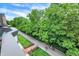 Scenic view of a walking path with walkers, lined with lush trees, and a blue sky at 906 Berkhamsted Ln, Carmel, IN 46032