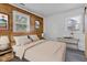 Comfortable bedroom with a wood accent wall, bright windows, and neutral decor at 917 W Busby St, Lebanon, IN 46052