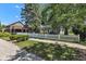 View of the home with a white picket fence, mature trees, and professional landscaping at 917 W Busby St, Lebanon, IN 46052