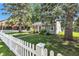 Inviting home featuring mature trees, green lawn, and a classic white picket fence at 917 W Busby St, Lebanon, IN 46052