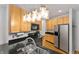 Bright kitchen featuring stainless steel appliances, granite countertops, maple cabinetry, and stylish light fixtures at 932 N Broadway St # 4, Indianapolis, IN 46202