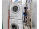 Efficient laundry area featuring a stacked washer and dryer, next to the home's mechanicals, saving space and adding convenience at 932 N Broadway St # 4, Indianapolis, IN 46202