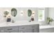 Bright bathroom featuring a double vanity with modern fixtures, illuminated mirrors, and a soaking tub at 10306 Tybalt Dr, Fishers, IN 46038