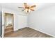 Simple bedroom featuring wood floors, a ceiling fan, and closet space, with an open doorway visible at 10306 Tybalt Dr, Fishers, IN 46038