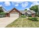 Attractive brick home featuring an attached garage and a neat front lawn at 10306 Tybalt Dr, Fishers, IN 46038