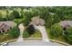 Aerial view of a brick home in a wooded neighborhood with a curved driveway at 10455 Trewithen Ln, Carmel, IN 46032