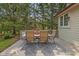 Outdoor dining on back deck with neutral colors and a picturesque setting with trees at 10455 Trewithen Ln, Carmel, IN 46032