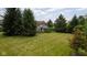Expansive, grassy backyard with mature trees bordering the property at 10455 Trewithen Ln, Carmel, IN 46032