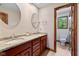 Bathroom featuring double sinks, granite countertops, cherry cabinets, and a separate toilet room at 10455 Trewithen Ln, Carmel, IN 46032