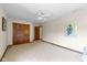 Spacious bedroom with neutral carpet, ceiling fan and natural wood trim and doors at 10455 Trewithen Ln, Carmel, IN 46032