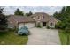 Beautiful brick home featuring an attached three car garage, driveway, and mature trees at 10455 Trewithen Ln, Carmel, IN 46032