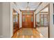 Inviting foyer with hardwood floors, wood trim, and glass paneled front door at 10455 Trewithen Ln, Carmel, IN 46032