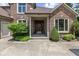 Close-up of the front door with brick exterior, mature landscaping, and charming wreath at 10455 Trewithen Ln, Carmel, IN 46032