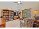 Cozy living room with bookshelves, comfortable armchairs, and a large window at 10455 Trewithen Ln, Carmel, IN 46032