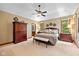 Spacious main bedroom featuring tray ceilings, a ceiling fan, large windows and beautiful wood furniture at 10455 Trewithen Ln, Carmel, IN 46032