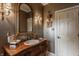 Bathroom with a beautiful wood vanity, gold mirror, and sconces, providing an elegant space at 1089 Laurelwood, Carmel, IN 46032