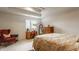 Well-lit bedroom with a queen bed, wood furniture, and a comfortable red chair in the corner at 1089 Laurelwood, Carmel, IN 46032