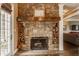 Stone fireplace with wooden mantel and built-in log storage, creating a cozy and inviting living space at 1089 Laurelwood, Carmel, IN 46032