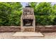 Outdoor fireplace with brick surround and rustic log storage area, perfect for backyard gatherings at 1089 Laurelwood, Carmel, IN 46032