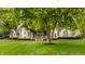 Stunning brick home featuring a lush green lawn, mature trees, and a circular driveway at 1089 Laurelwood, Carmel, IN 46032
