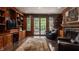 Cozy living room with wood paneled walls, fireplace, built-in shelves, and access to backyard at 1089 Laurelwood, Carmel, IN 46032