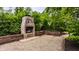 Outdoor brick fireplace with wooden benches surrounded by a gravel area and lush foliage at 1089 Laurelwood, Carmel, IN 46032