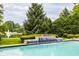 A beautiful pool features an elegant water feature with a view of the lake and trees at 1089 Laurelwood, Carmel, IN 46032