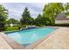 A backyard pool with an elegant design and a refreshing waterfall feature surrounded by green landscape at 1089 Laurelwood, Carmel, IN 46032